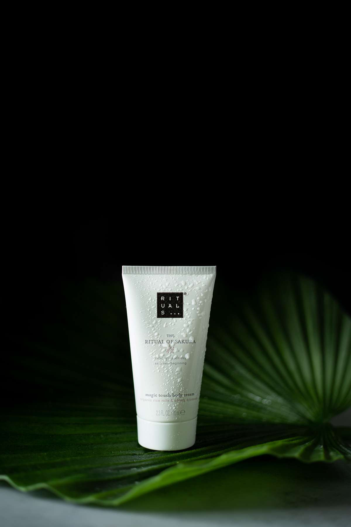 White bottle of body cream with a professional tropical background