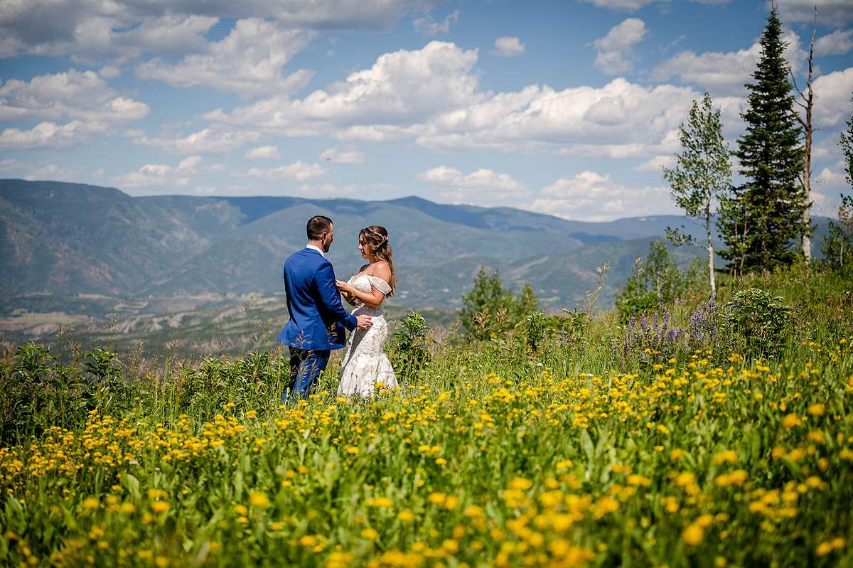 First look and Vow reading in wildflower meadow in the mountains