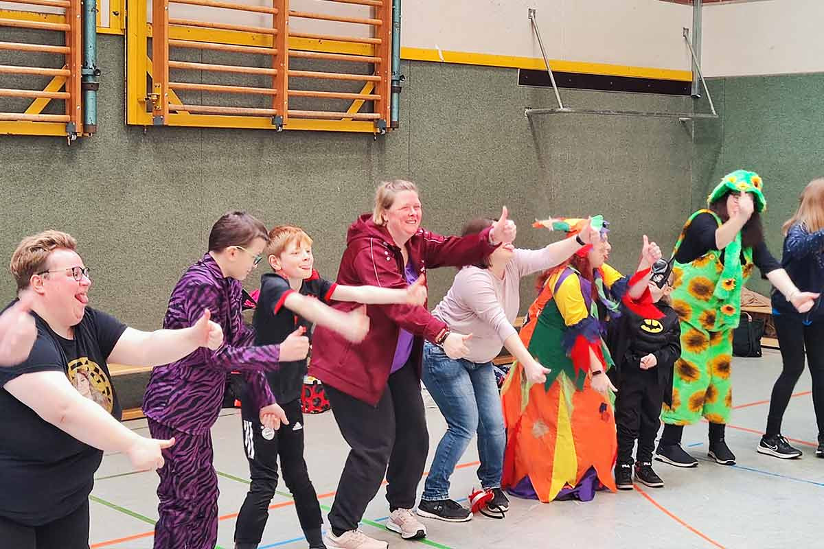 Spielerinnen und Spieler in bunten Karnevalskostümen.