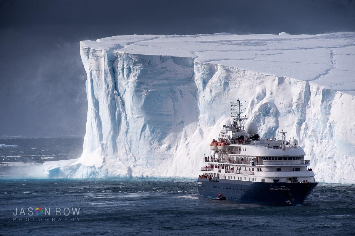 Cruise ship beside massive tabular iceberg in Antarctica.  By Jason Row Photography.