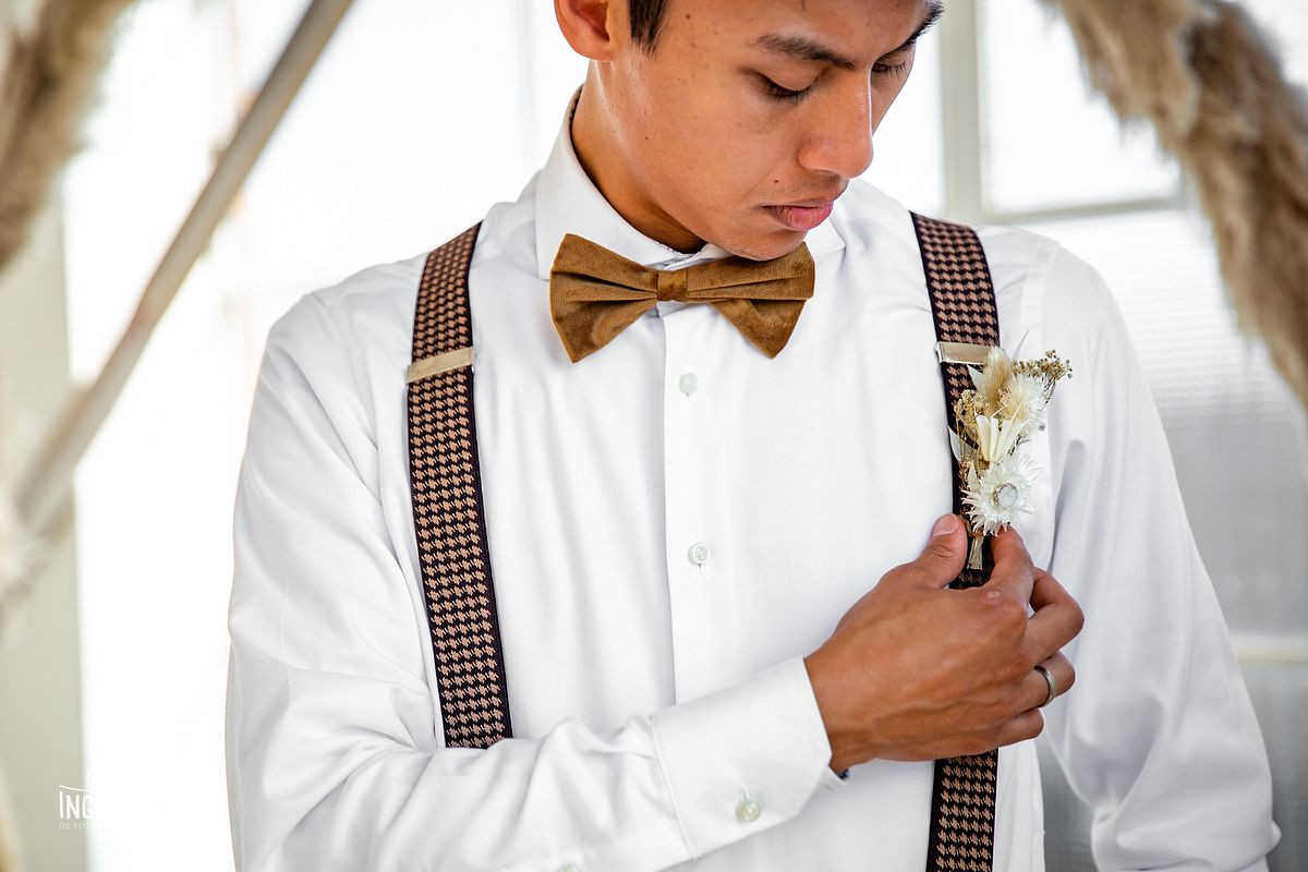 Bruidegom hangt corsage recht