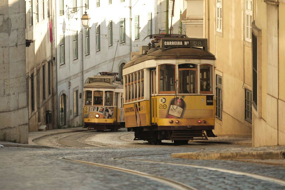 Two trams pass in narrow Lisbon Street