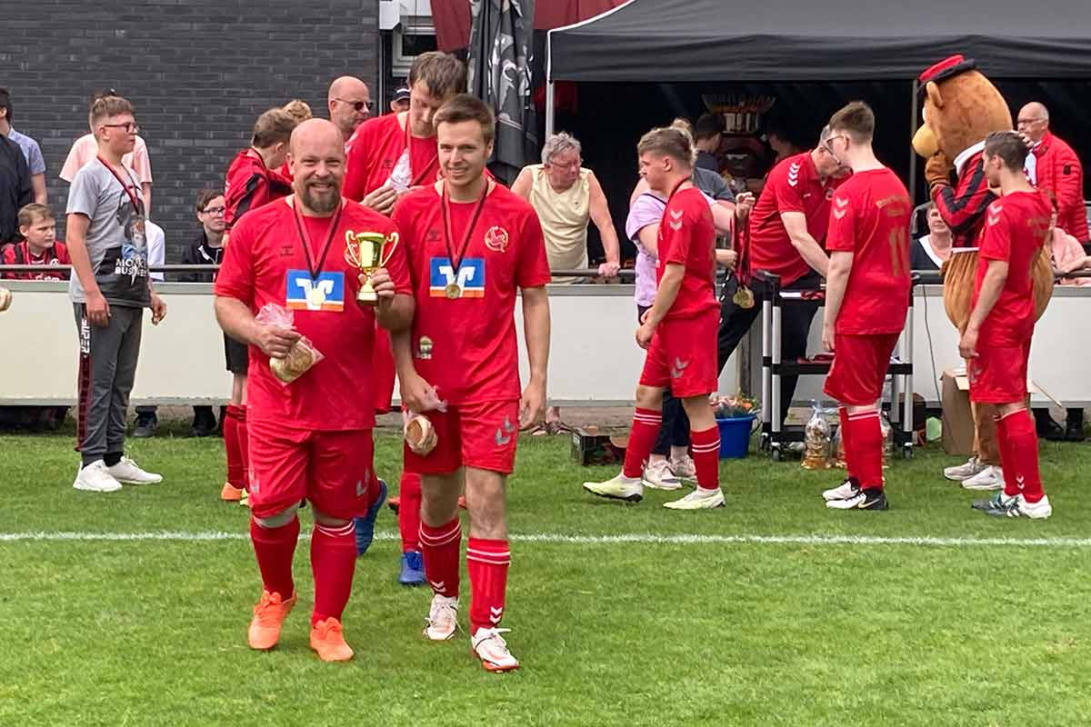 Spielerinnen und Spieler nehmen stolz ihre Medaillen bei der Siegerehrung entgegen