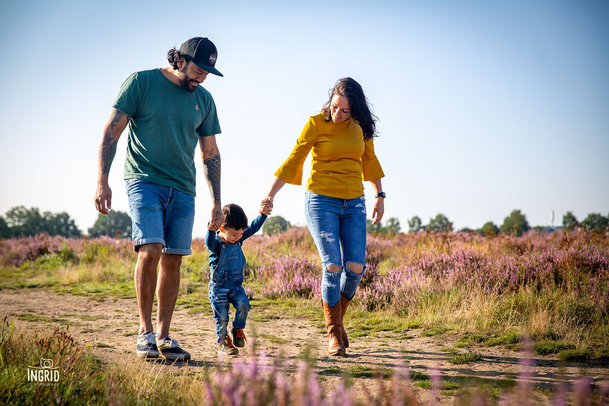 Papa mama en kindje tijdens fotoshoot op de paarse heide