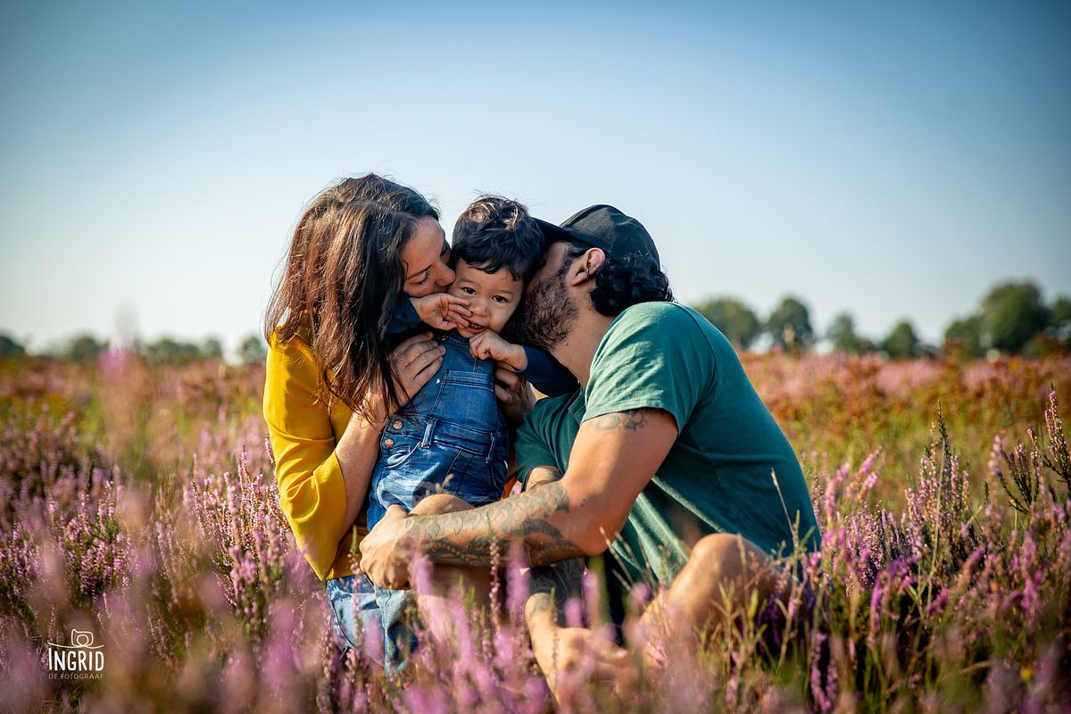 Papa en mama geven zoontje kus